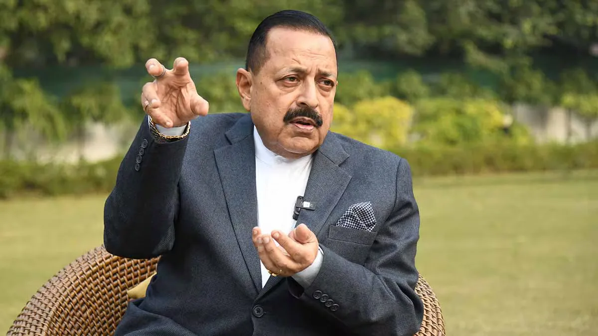 Dr. Jitendra Singh seated outdoors, speaking and gesturing with both hands