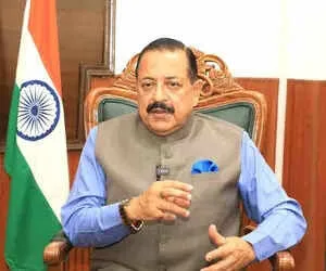 Dr. Jitendra Singh seated in a carved chair beside the national flag