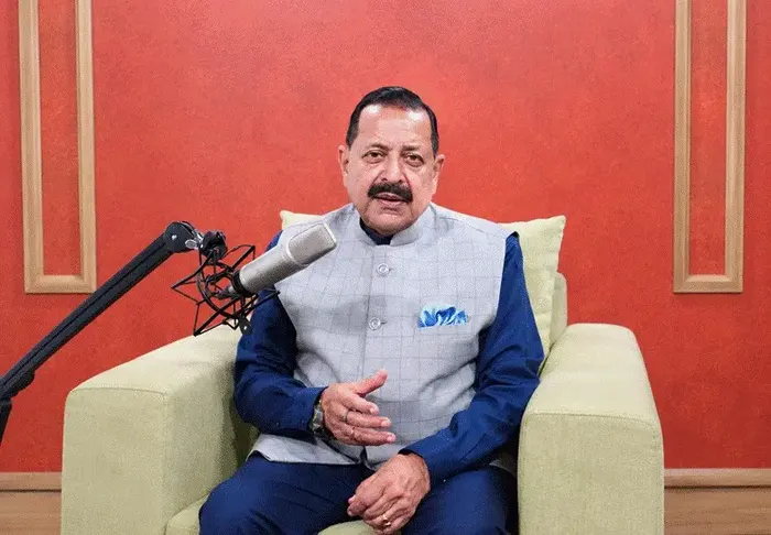 Dr. Jitendra Singh seated in a studio beside a podcast microphone