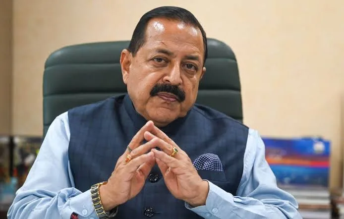 Dr. Jitendra Singh seated in a high-backed chair, hands steepled
